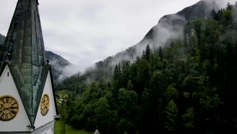 Slovenia-Small-Town-Surrounded-By-Misty-Pine-Forest-Mountains-Aerial-Drone-3