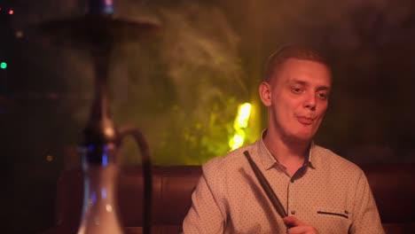 man smoking hookah in a lounge