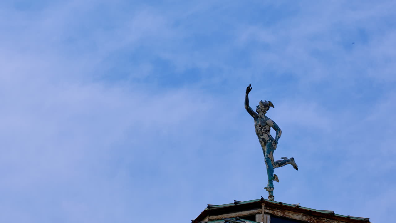 4K time-lapse of the Roman god Mercury statue atop the Winter Garden dome in Avery Hill Park, South East London, with drifting clouds and dynamic sky creating a historic, mythological scene