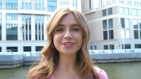 young woman smiling in front of a building