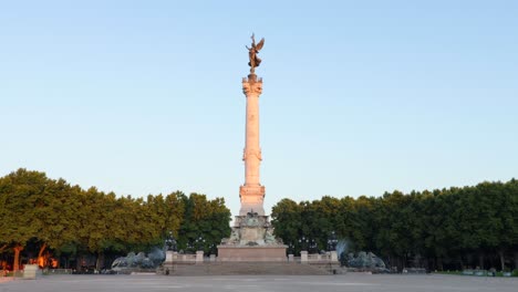 monumento aux girondains en burdeos en la plaza quinconces durante el amanecer sin nadie y algunos tranvías