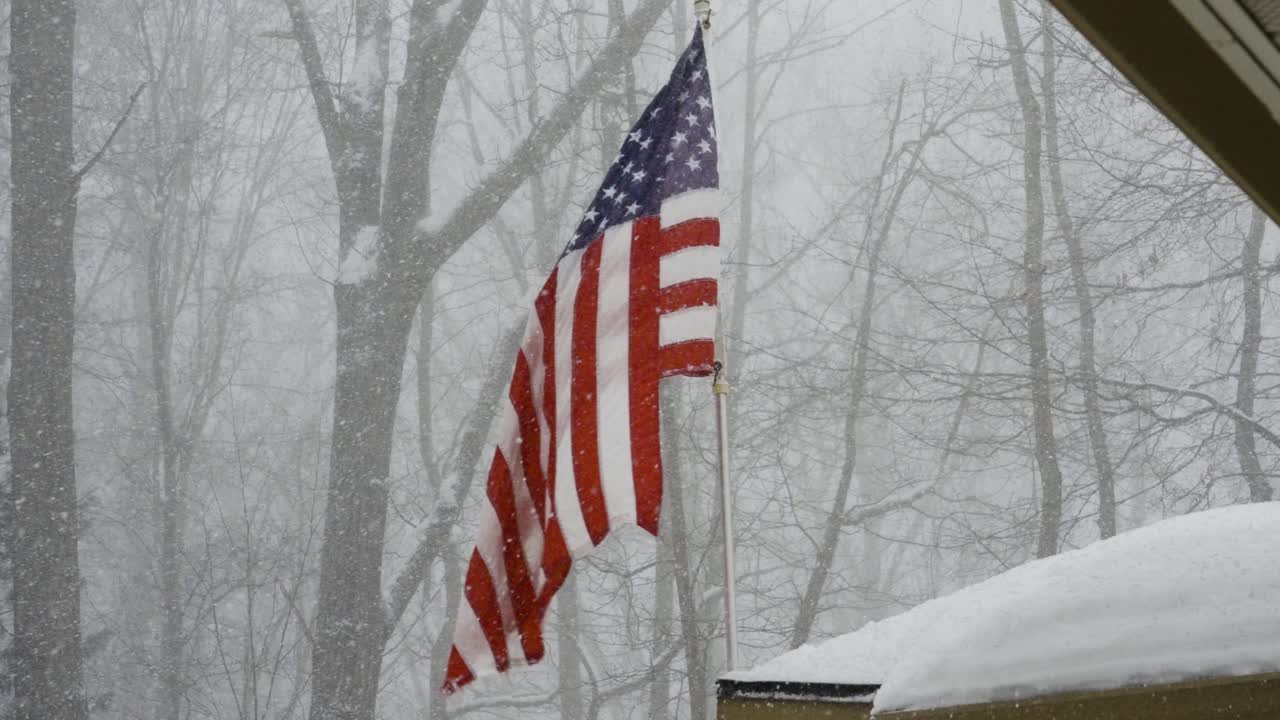 Una bandiera americana che resiste salda in una bufera di neve a gennaio