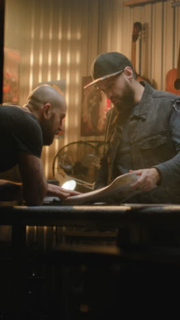 two luthiers working on a guitar in a workshop