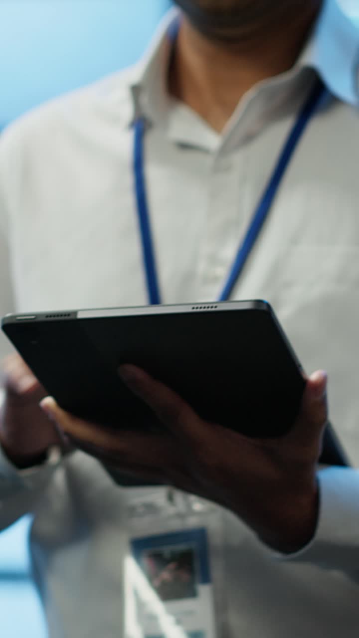 Close-up of Professional Hands Using Digital Tablet with ID Badge