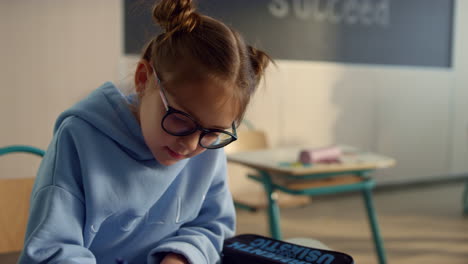 focused child studying in class. smart girl writing in notebook at lesson