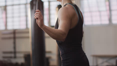 mujer caucásica en forma trabajando con cuerdas de salto en el gimnasio