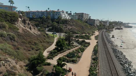 Vista-Aérea-De-Dos-Damas-Caminando-Por-El-Sendero-De-La-Playa-Cerca-De-San-Clemente,-California