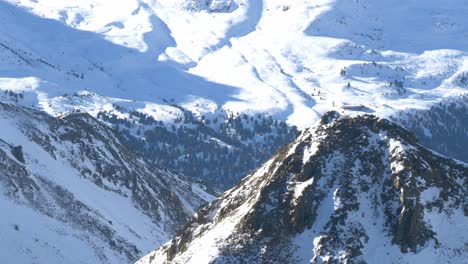 Overlooking-a-valley-high-up-from-snowy-alpines-in-the-Alps-of-Tyrol---pan-view