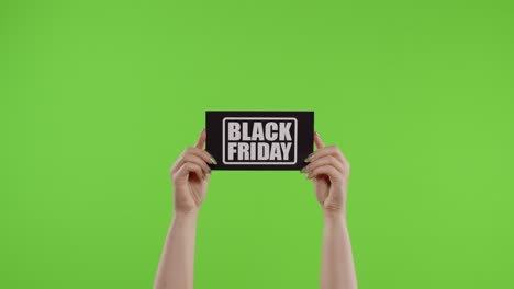 Black-Friday-advertisement-inscription-on-paper-sheet-in-womans-hands-on-chroma-key.-Slow-motion