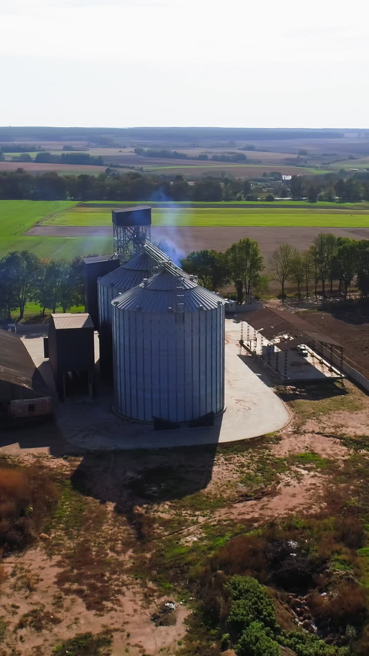 Aerial view. Metal grain elevator in agricultural zone. Grain warehouse Vertical video