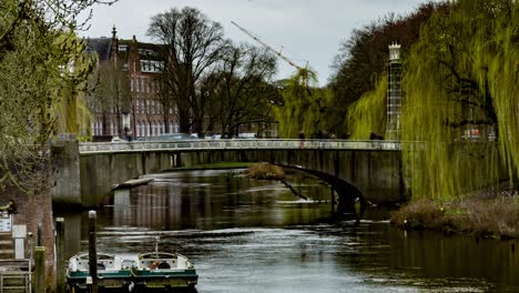 Medium-Time-lapse-of-people-and-cars-crossing-bridge-over-river-in-Den-Bosch,-the-Netherlands