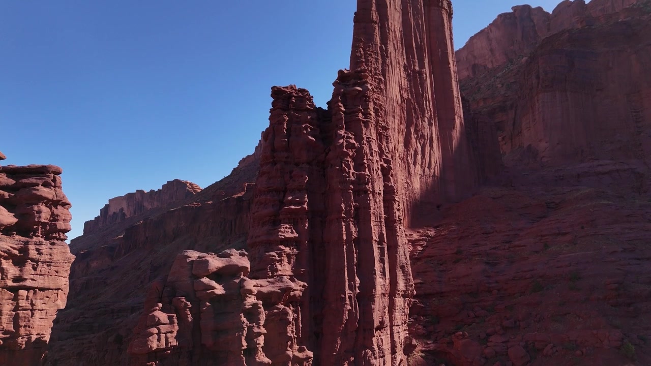 Drone che vola dritto verso l'alto con la telecamera che si inclina verso il basso sulle Fisher Towers a Moab, USA, in 4K