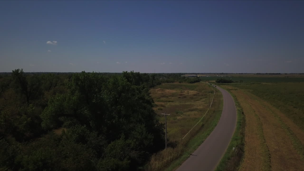 toma aérea de seguimiento de automóviles circulando por una carretera rural