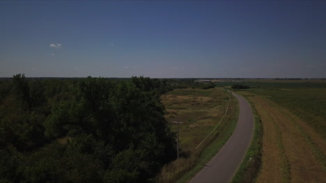 Aerial-tracking-shot-of-cars-driving-along-a-country-road