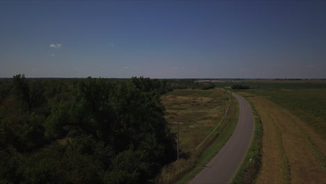 aerial tracking shot of cars driving along a country road