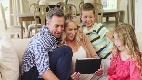 happy family using digital tablet in living room
