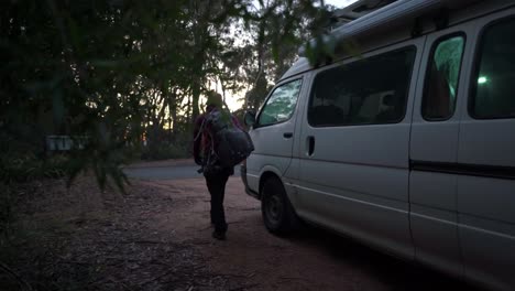 Indigenous-Australian-girl-getting-her-backpack-out-of-her-van-to-go-hiking-during-sunrise