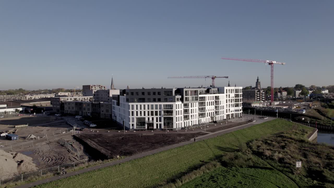 complejo de apartamentos kade noord en la orilla del río ijssel que revela el sitio de construcción de kade zuid con grandes grúas rojas en el barrio noorderhaven de tower town zutphen