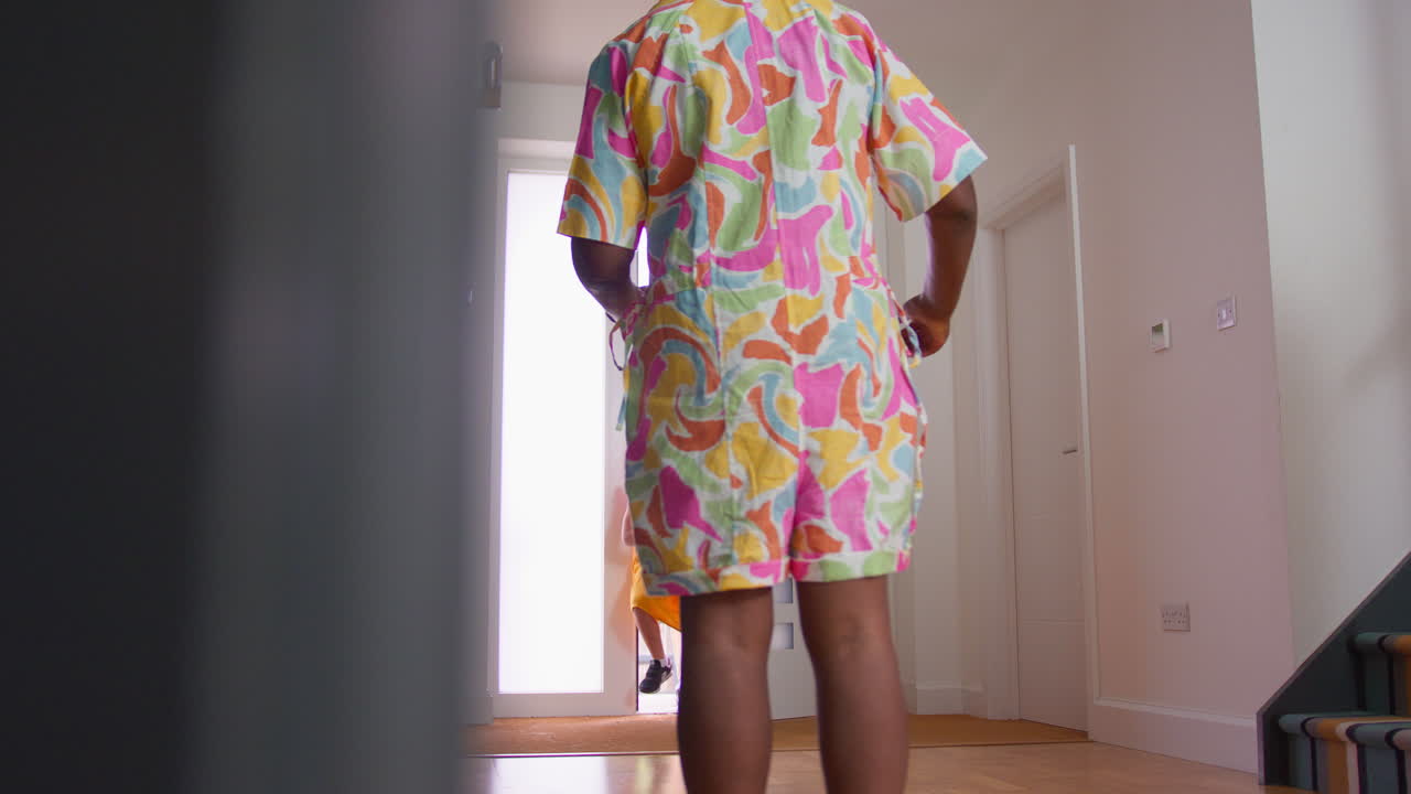 familia multigeneracional con abuelos saludando a los nietos en el pasillo de la casa