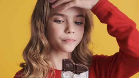 Teenage-Caucasian-girl-eating-chocolate-bar-and-nodding.