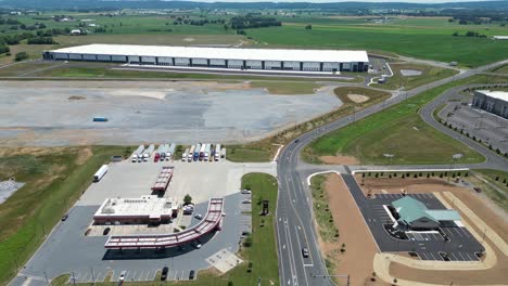 aerial drone view of business park that includes gas station, warehouses, and factories