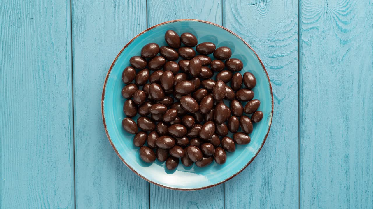 los caramelos de chocolate desapareciendo de un cuenco. detener el movimiento. vista superior.