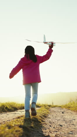 child in field with plane toy