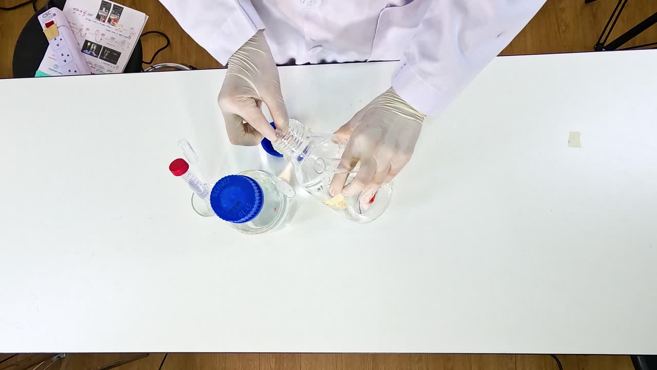 A scientist conducts a potassium permanganate reduction experiment using glassware and chemicals on a lab table