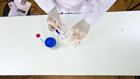a scientist conducts a potassium permanganate reduction experiment using glassware and chemicals on a lab table