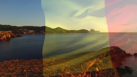 digital composition of belgium flag waving against aerial view of waves in the sea