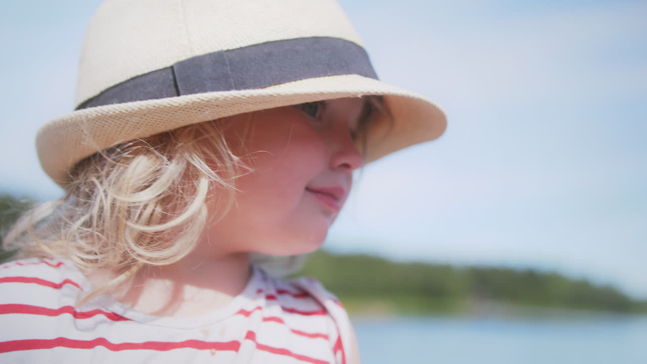 여름 환경에서 모자를 입은 아름다운 금발 어린 소녀, 멀리 바라보고, 가까운 초상화