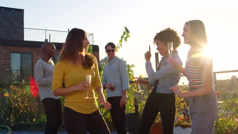 young adult friends dancing at a rooftop party