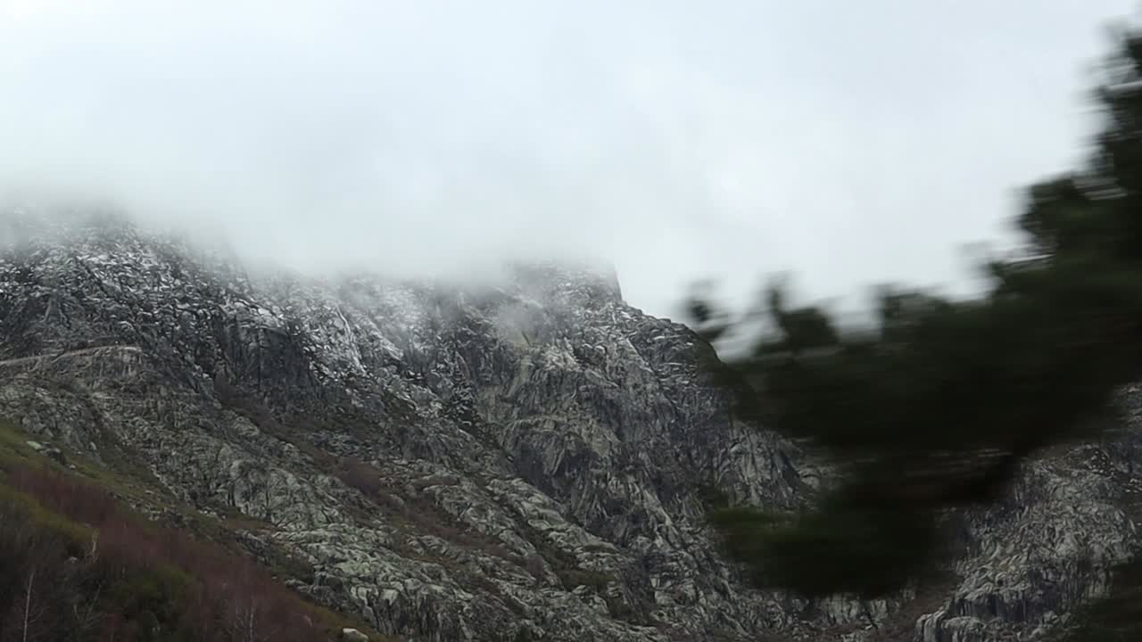 View of Mountain Peak Covered by Clouds on a Foggy Day While Driving Up Road Toward Serra da Estrela