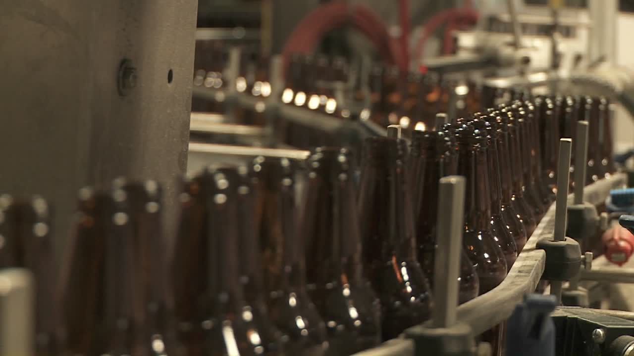 flasker zip langs et transportbånd i et flaskeanlegg 6