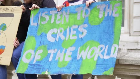 listen to the cries of the world protest sign