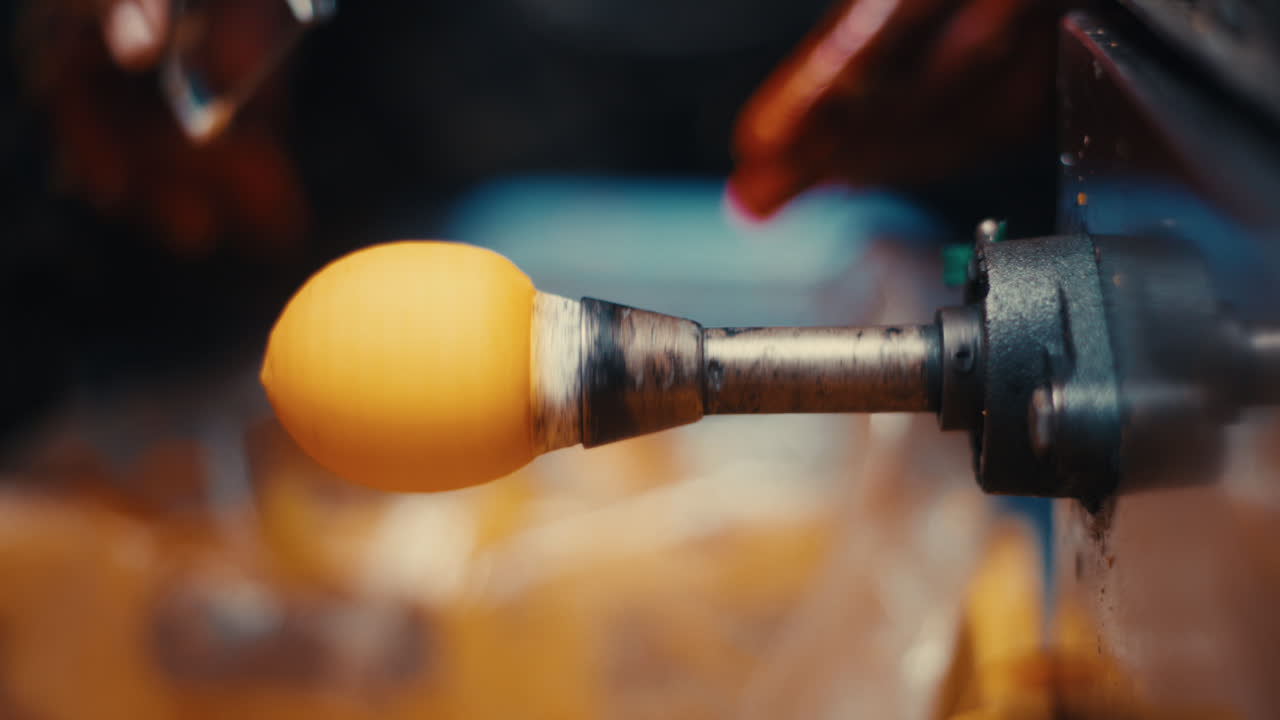 Hand peeling persimmon skin with a peeler attachment on a spinning machine