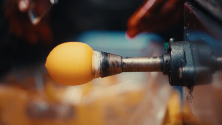 Hand peeling persimmon skin with a peeler attachment on a spinning machine