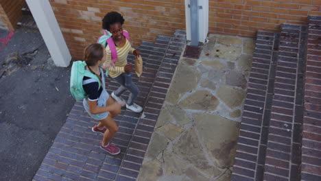 walking up stairs, two girls with backpacks talking after school
