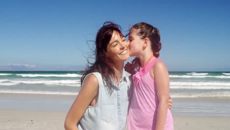 hija afectuosa besando a su madre en la playa