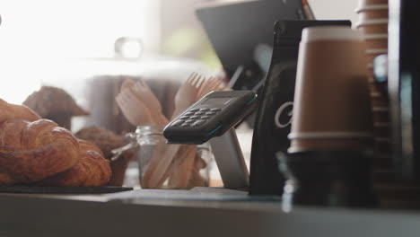 cerca del cliente pagando con tarjeta de crédito servicio de pago sin contacto comprando café en un café gastando dinero en un restaurante