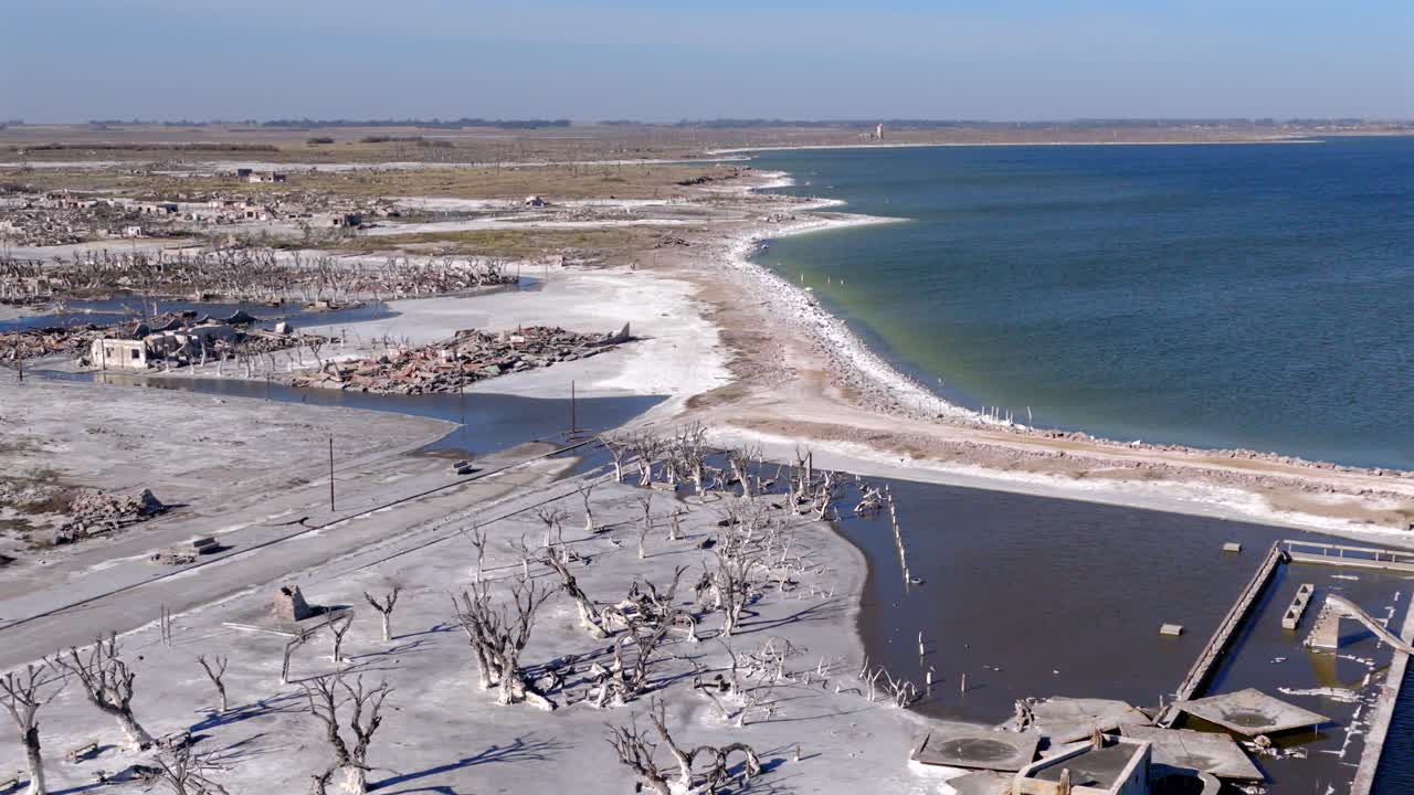 Cinematisk luftoptagelse, der bevæger sig hen over de forkalkede rester af Laguna Epecuéna, en druknet by. Den fremhæver kontrasten mellem den hvide salt skorpe og det dybblå, salte vand i Pampas, Argentina.