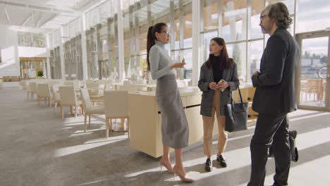 three business colleagues conversing in a modern office lounge