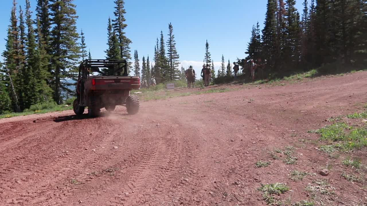 vehículo todoterreno alejándose por una carretera de montaña