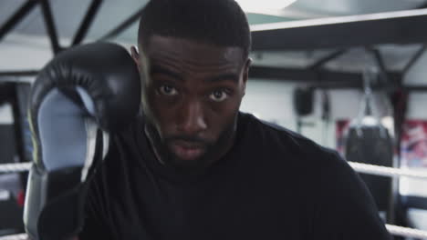 point of view shot of male boxing coach in gym sparring in boxing ring