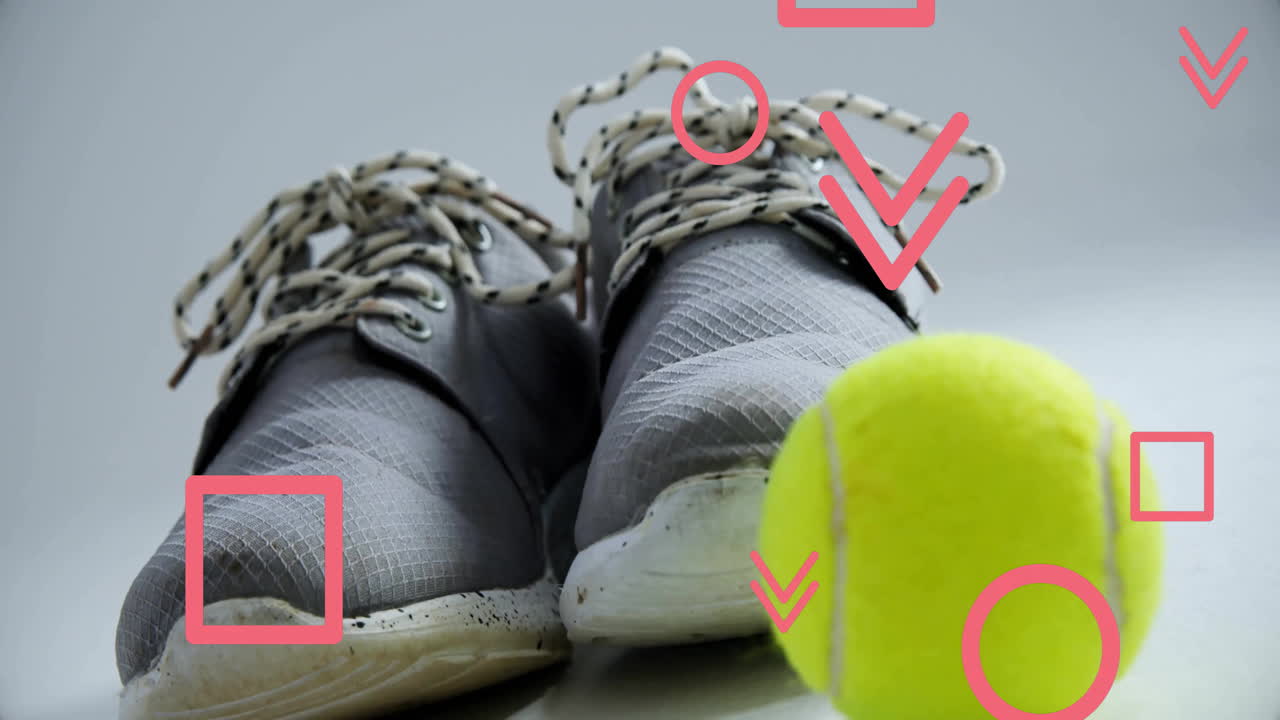 Gray sneakers resting on reflective floor in animated studio, showing tennis ball and red overlays