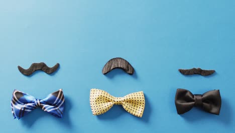 video de tres variados bigotes falsos y pajaritas en fondo azul con espacio de copia
