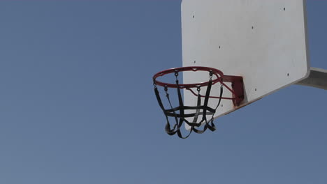 a man dunks a basketball and hangs on the rim for awhile