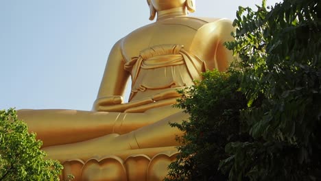 Golden-Big-Buddha-at-the-temple-Wat-Paknam,-Bangkok,-Thailand---blue-sky