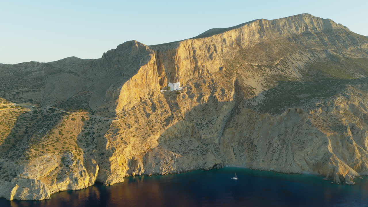 The Panagia Hozoviotissa Monastery on steep cliff above Aegean sea at sunrise, Amorgos Island, Aerial panoramic view