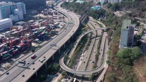 Vista-Aérea-De-Drones-De-La-Carretera-De-Cruce-De-Varios-Niveles-Con-Camión-En-Movimiento-Durante-El-Día